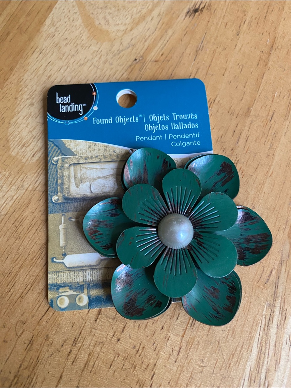 This item is a Found Objects floral metal pendant by the brand Bead Landing